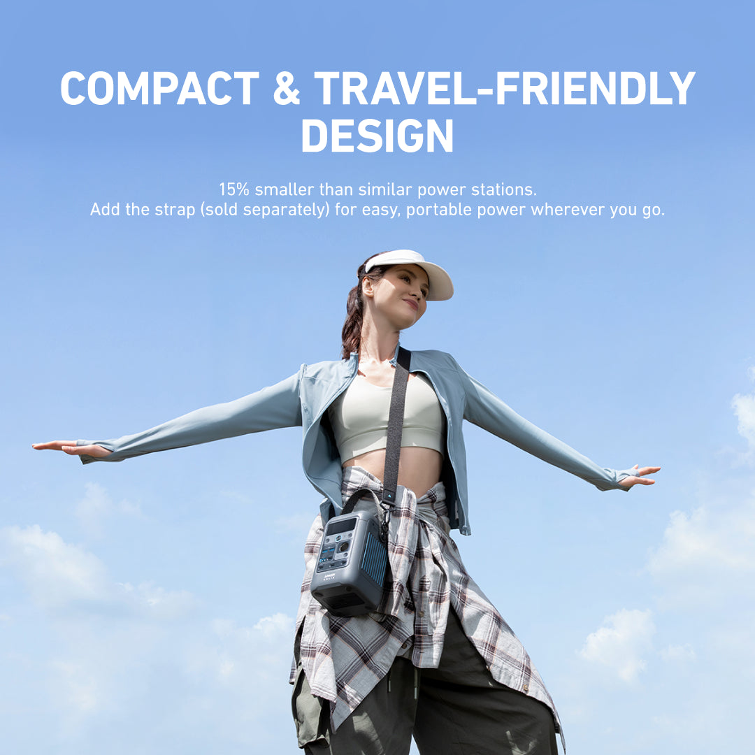 Person with a compact power station against a blue sky, promoting its travel-friendly design.